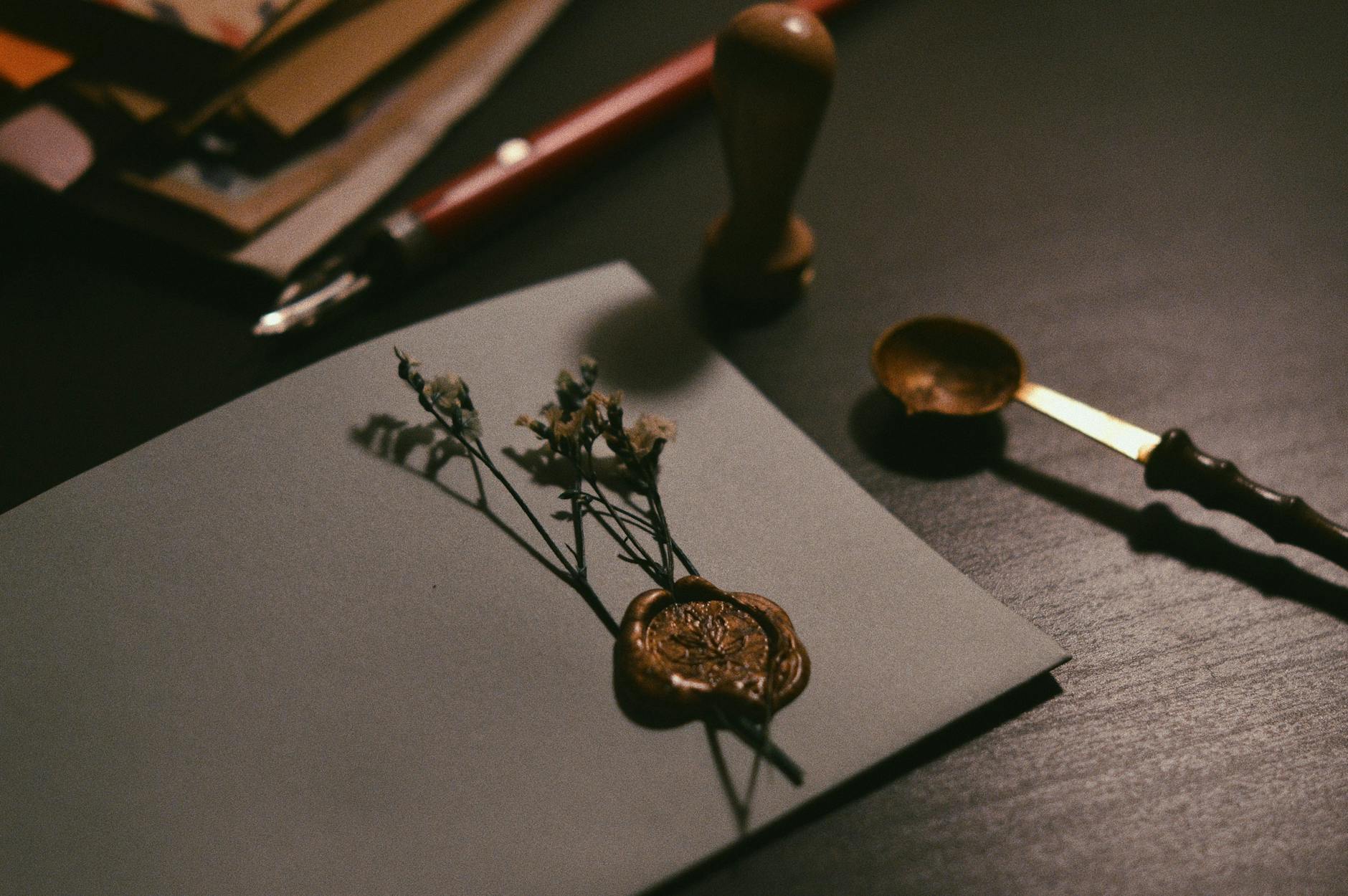 A vintage letter with wax seal and flowers on a desk, evoking nostalgia.